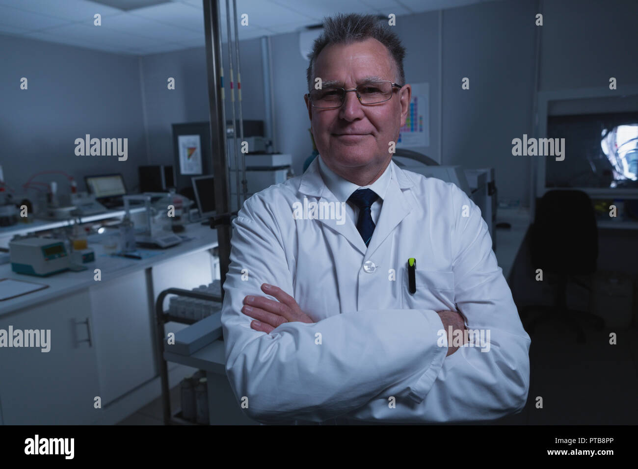 Male scientist standing with arms crossed in laboratory Stock Photo