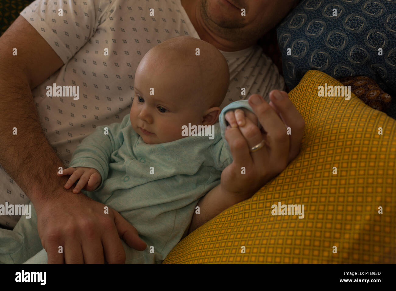 Father and baby boy relaxing on a sofa Stock Photo