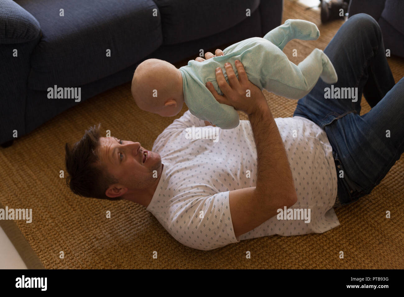 Father playing with his baby boy in living room Stock Photo