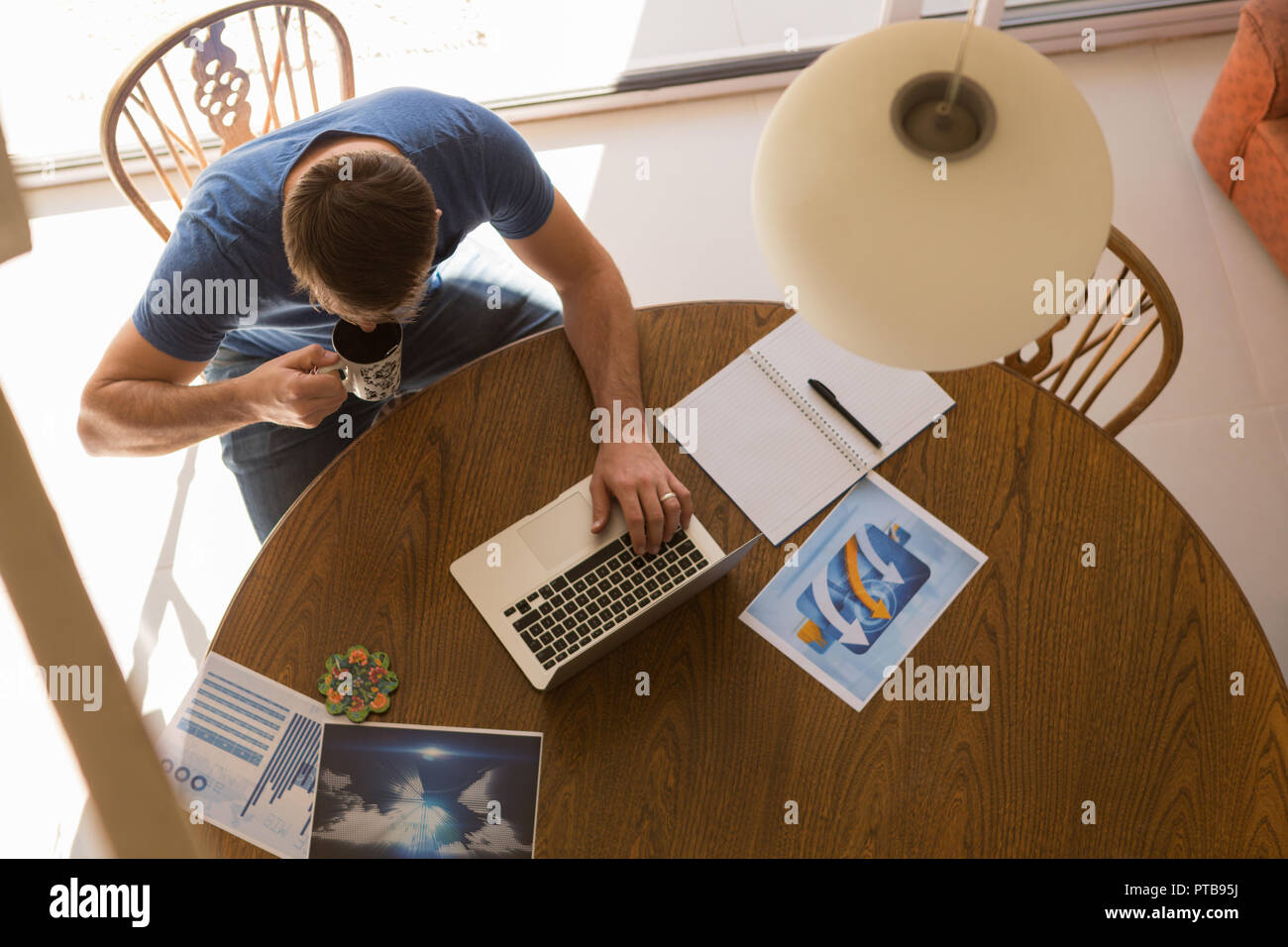 Man using laptop while having coffee Stock Photo