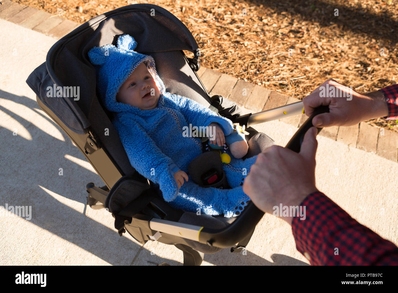Father walking with his baby boy in a pram Stock Photo