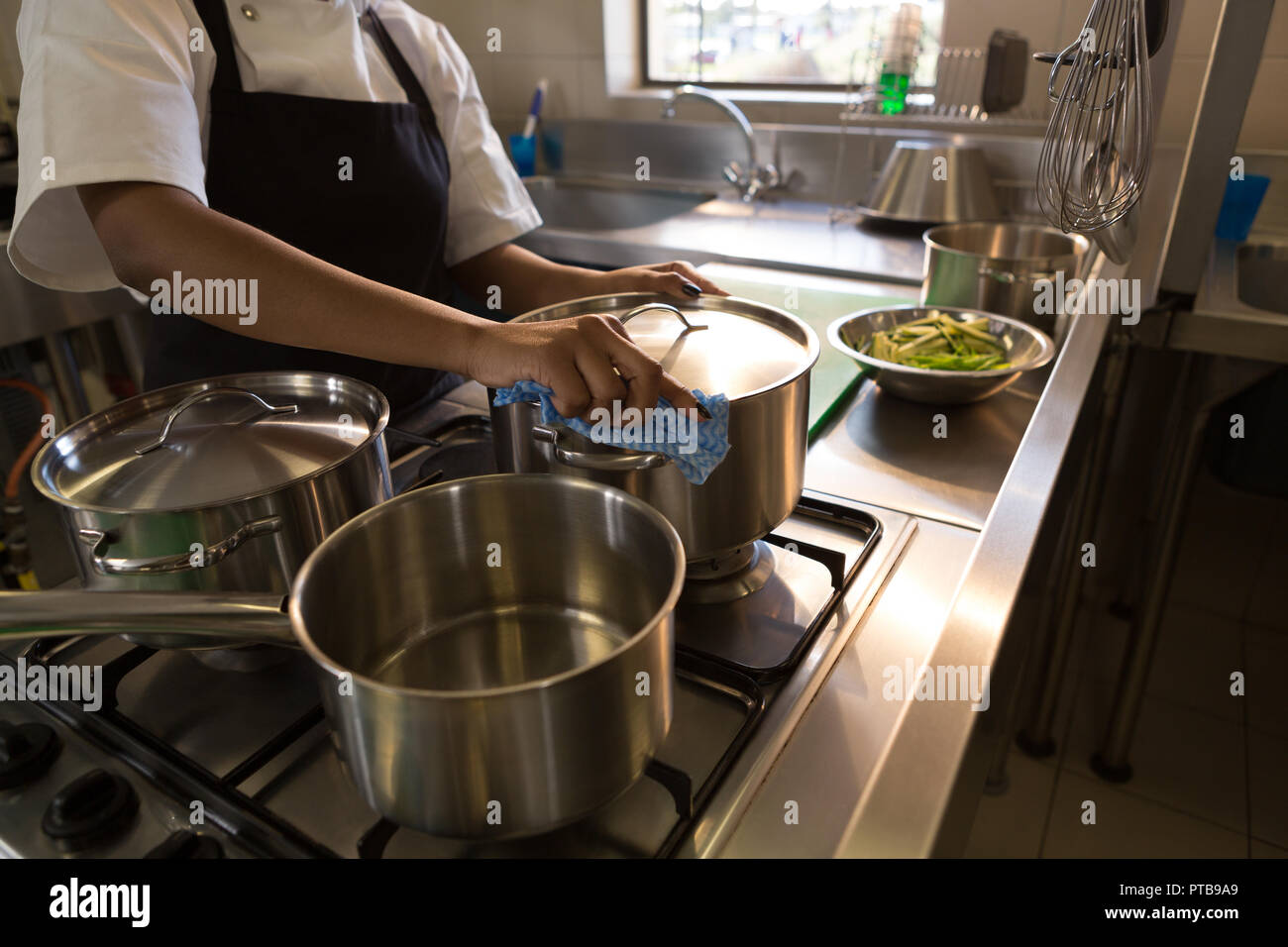 Chef preparing food in kitchen at restaurant Stock Photo