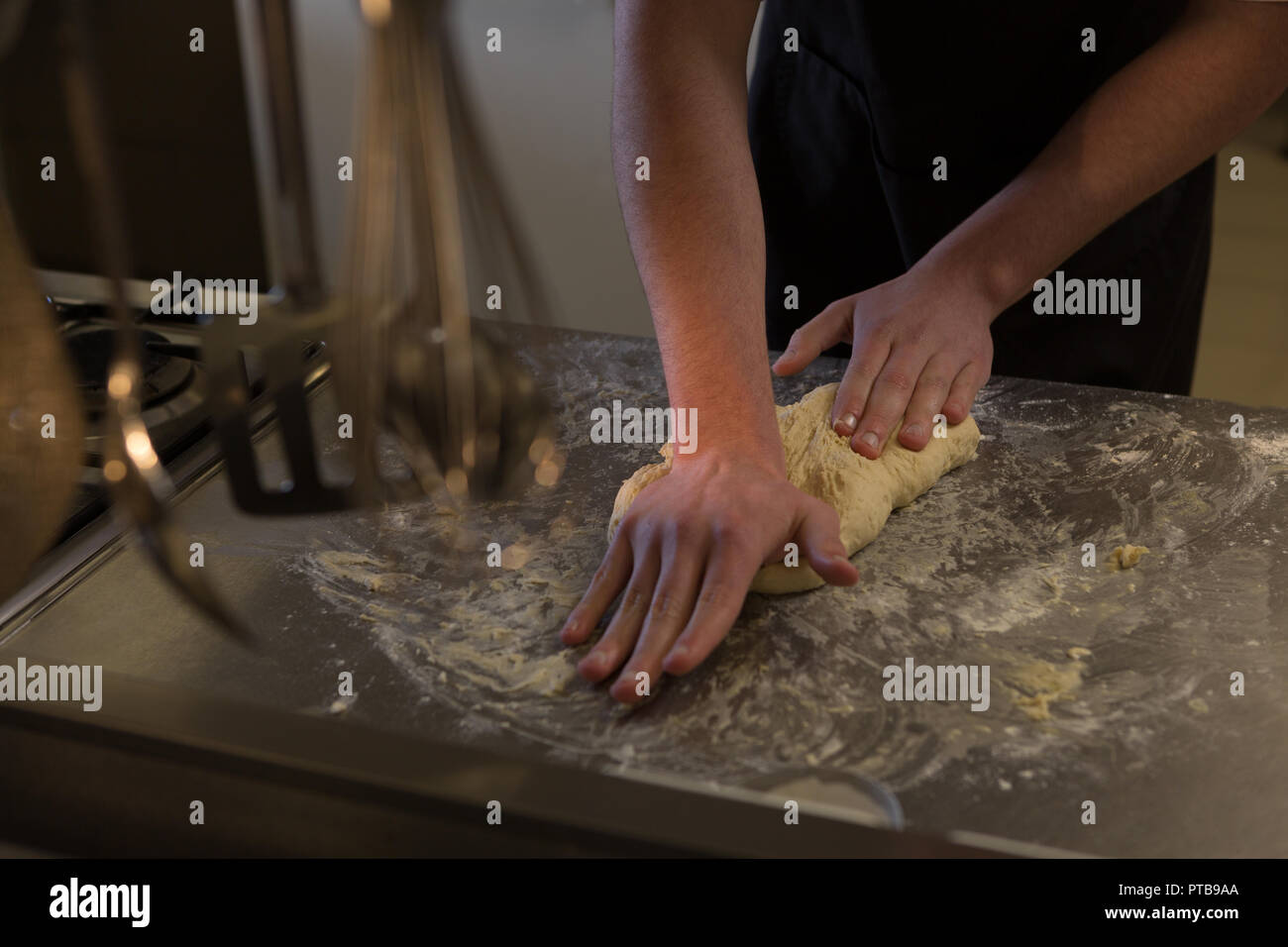 Chef kneading dough in kitchen at restaurant Stock Photo