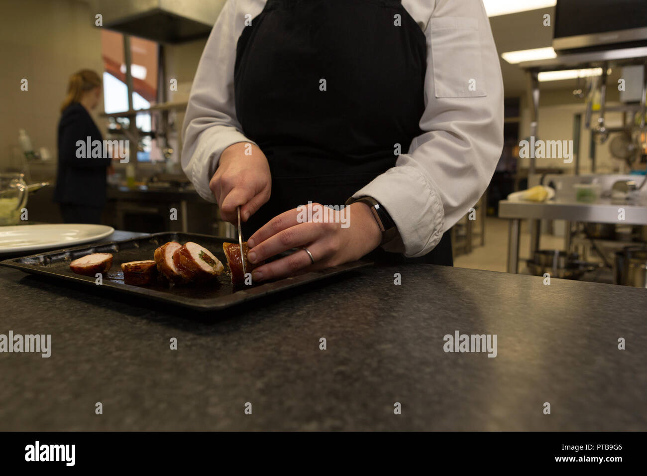 Chef cutting bacon with knife in restaurant Stock Photo