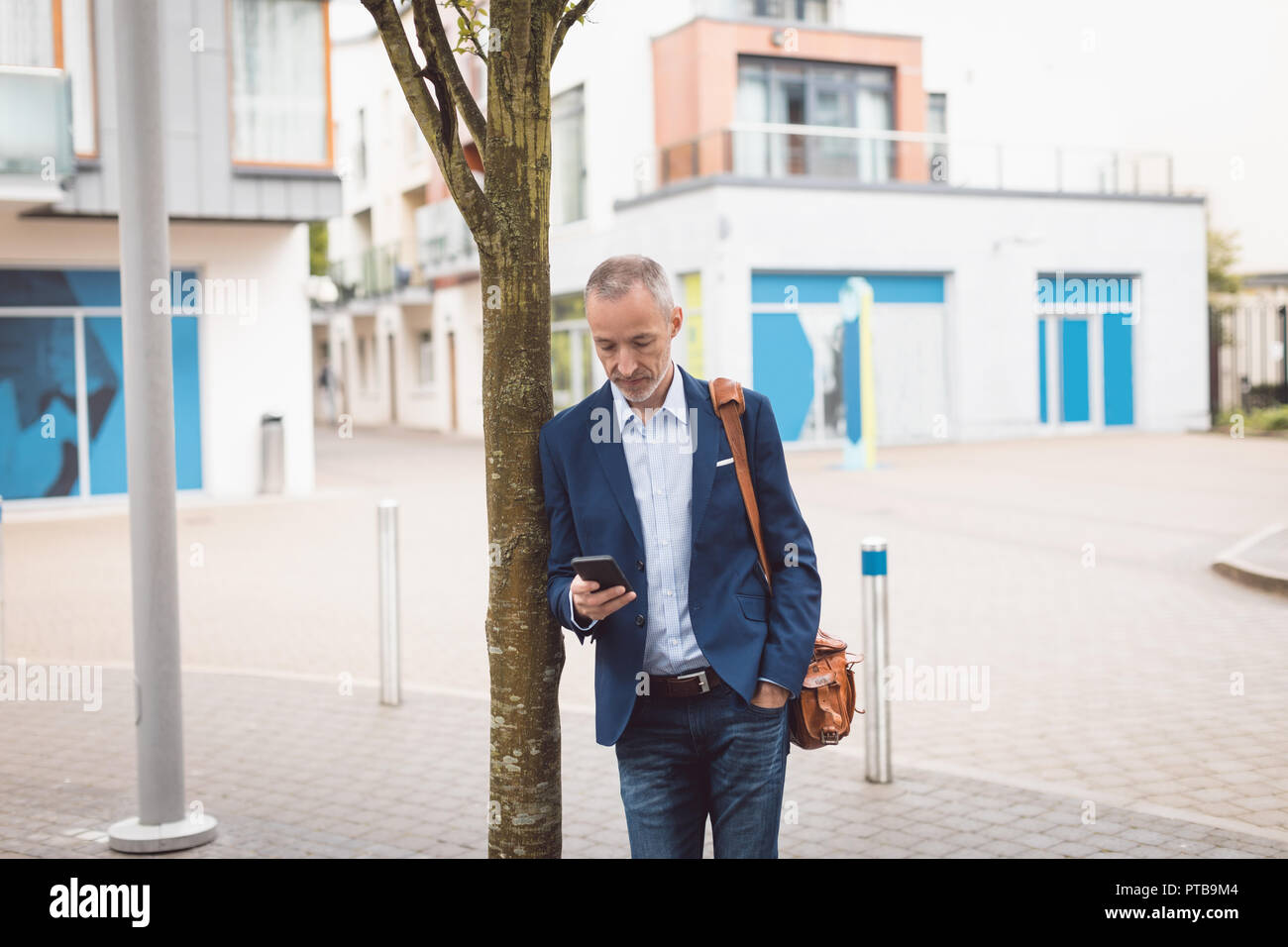 Businessman using mobile phone in city Stock Photo