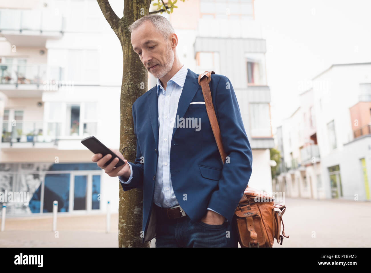 Businessman using mobile phone in city Stock Photo