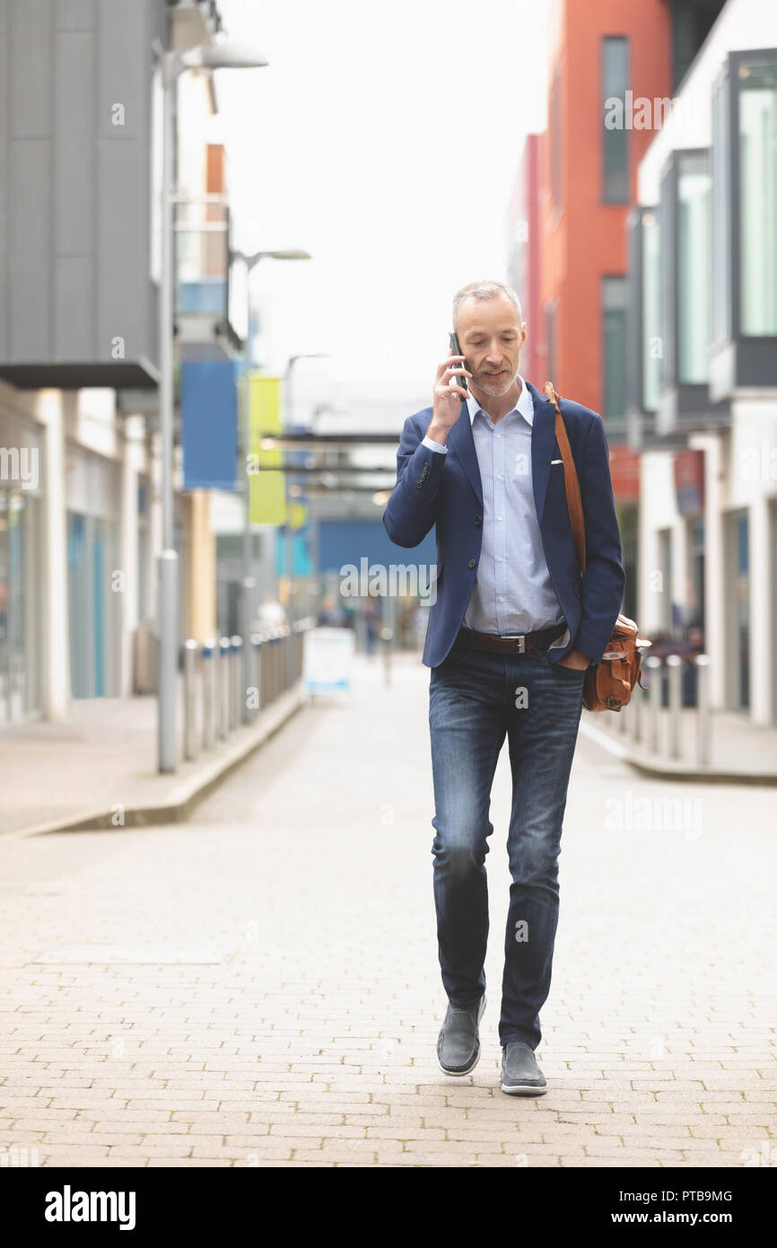 Businessman talking on mobile phone in city Stock Photo