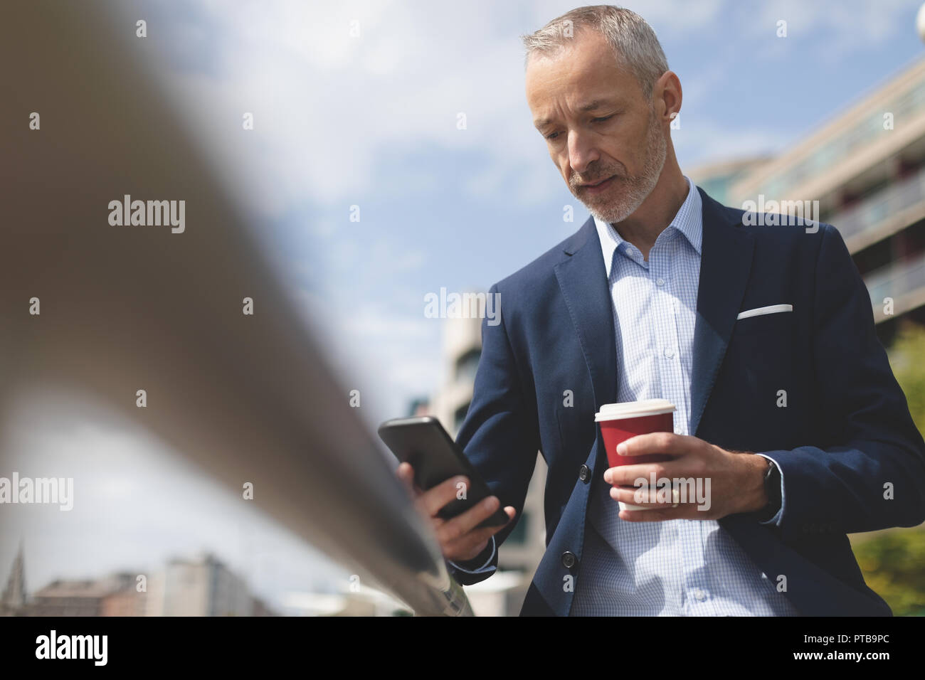 Businessman using mobile phone at promenade Stock Photo
