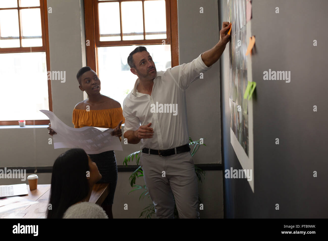 Business colleagues discussing over a sticky notes Stock Photo