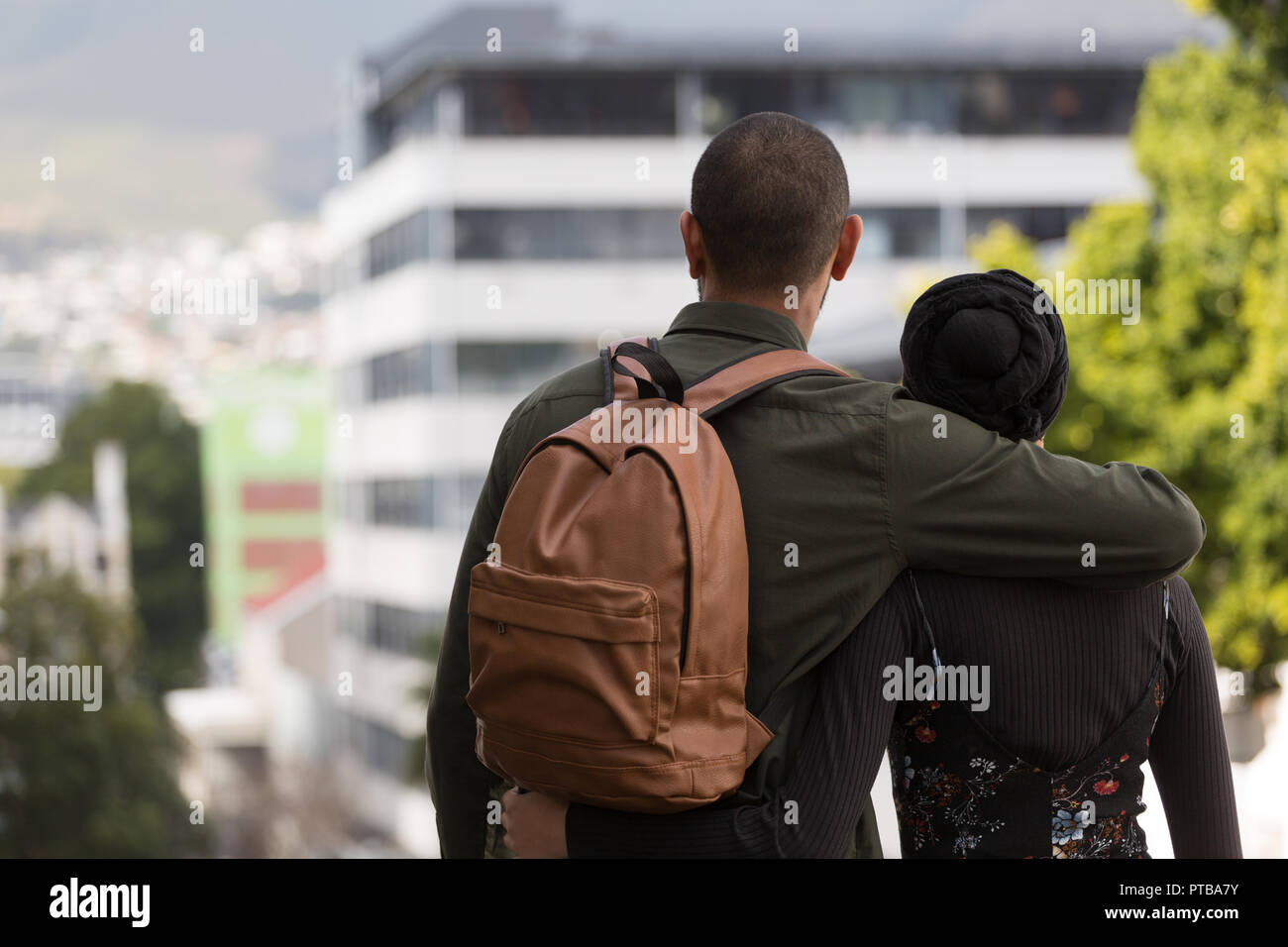 Couple standing with arm around in city Stock Photo