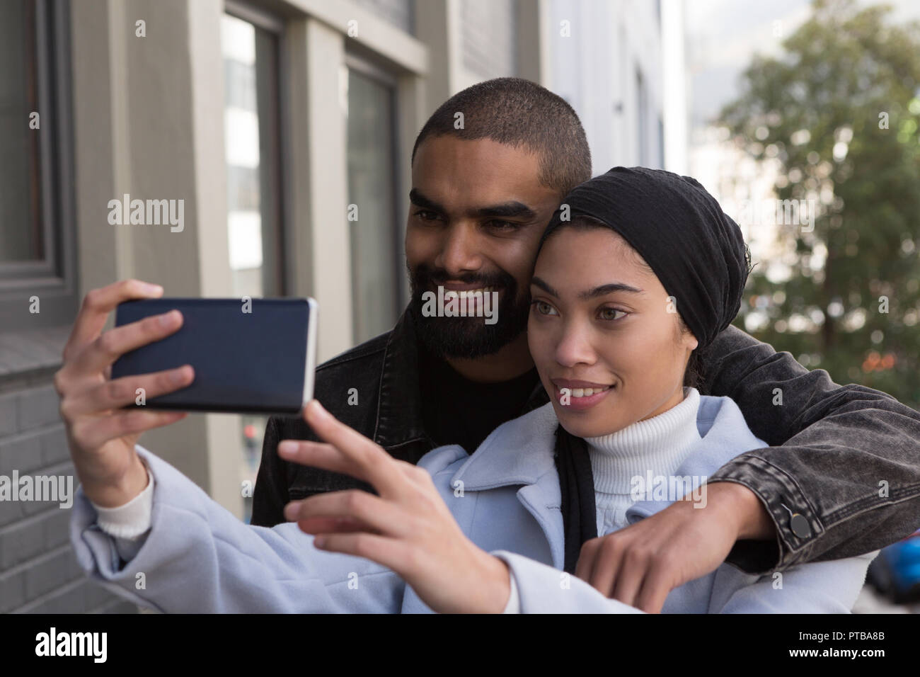 Couple taking selfie on city street Stock Photo