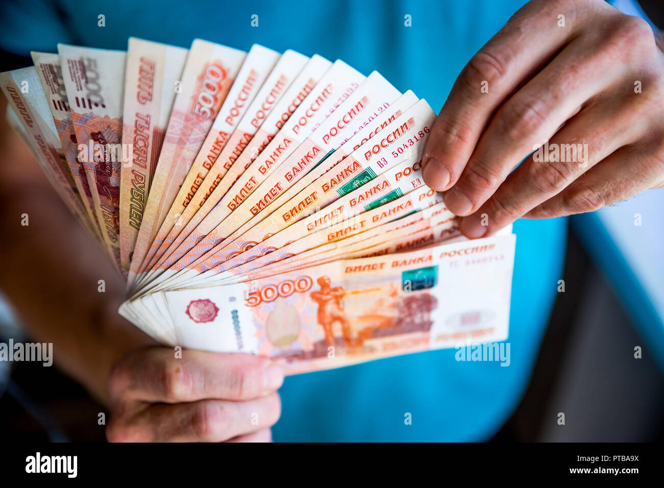 Russian rubles in the hand of a fan.male hand holding many of the Russian banknotes.The transfer of money.The isolated five-thousandth of Russian rubles denominations in a hand Stock Photo