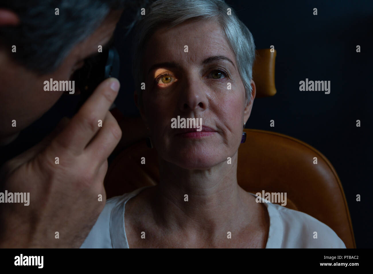 Optometrist examining patient eyes with ophthalmoscope Stock Photo Alamy