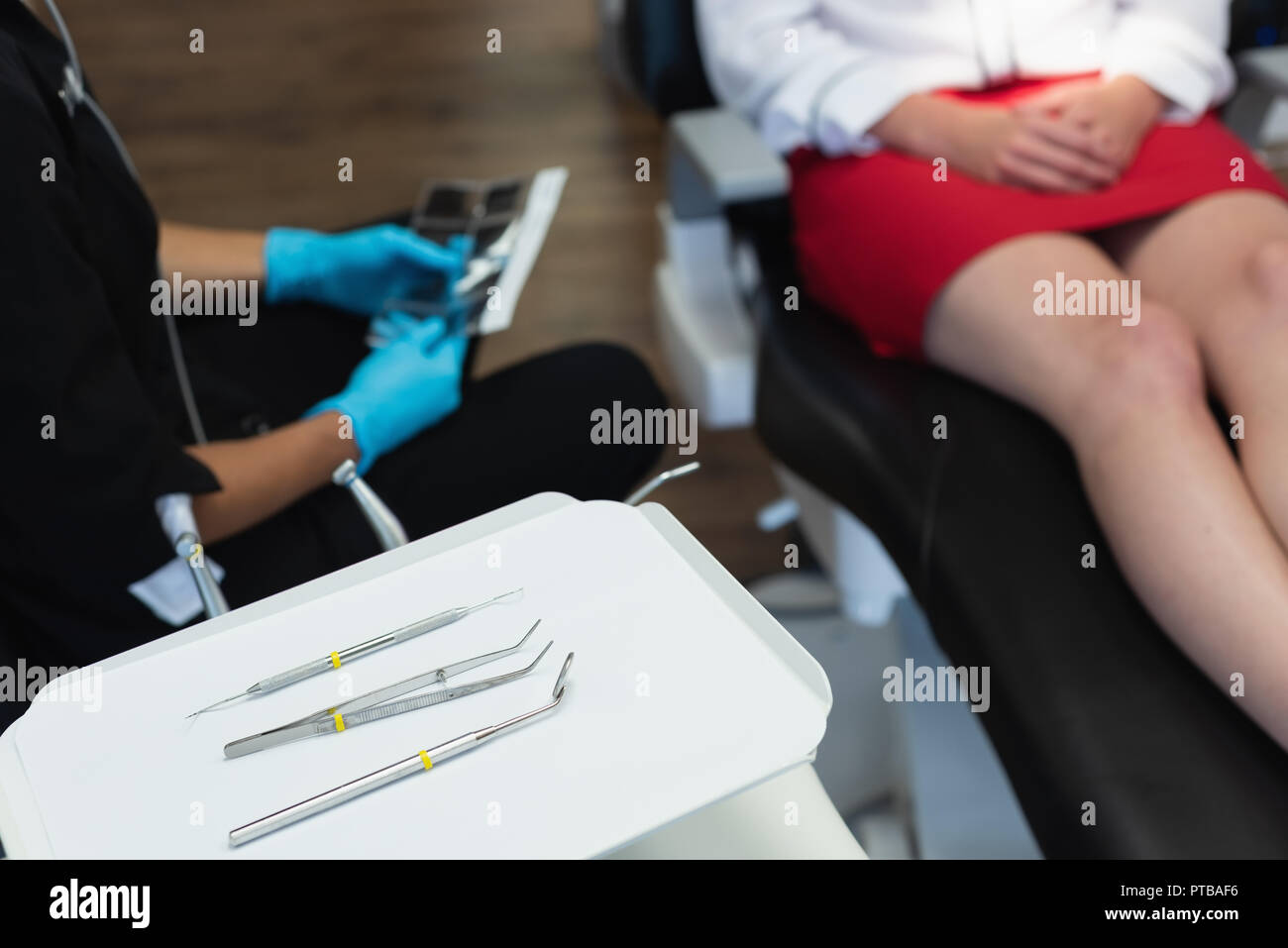 Dental tools in tray while female dentist interacting with patient Stock Photo Alamy