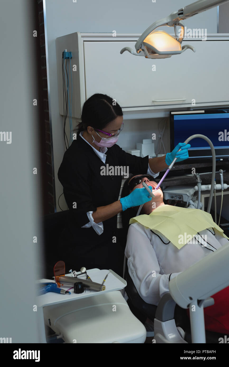 Female dentist examining a patient with tools Stock Photo