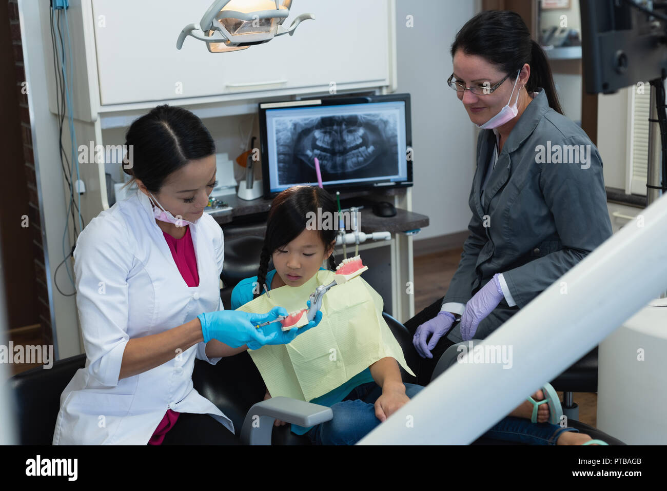 Female dentist explaining about teeth model Stock Photo