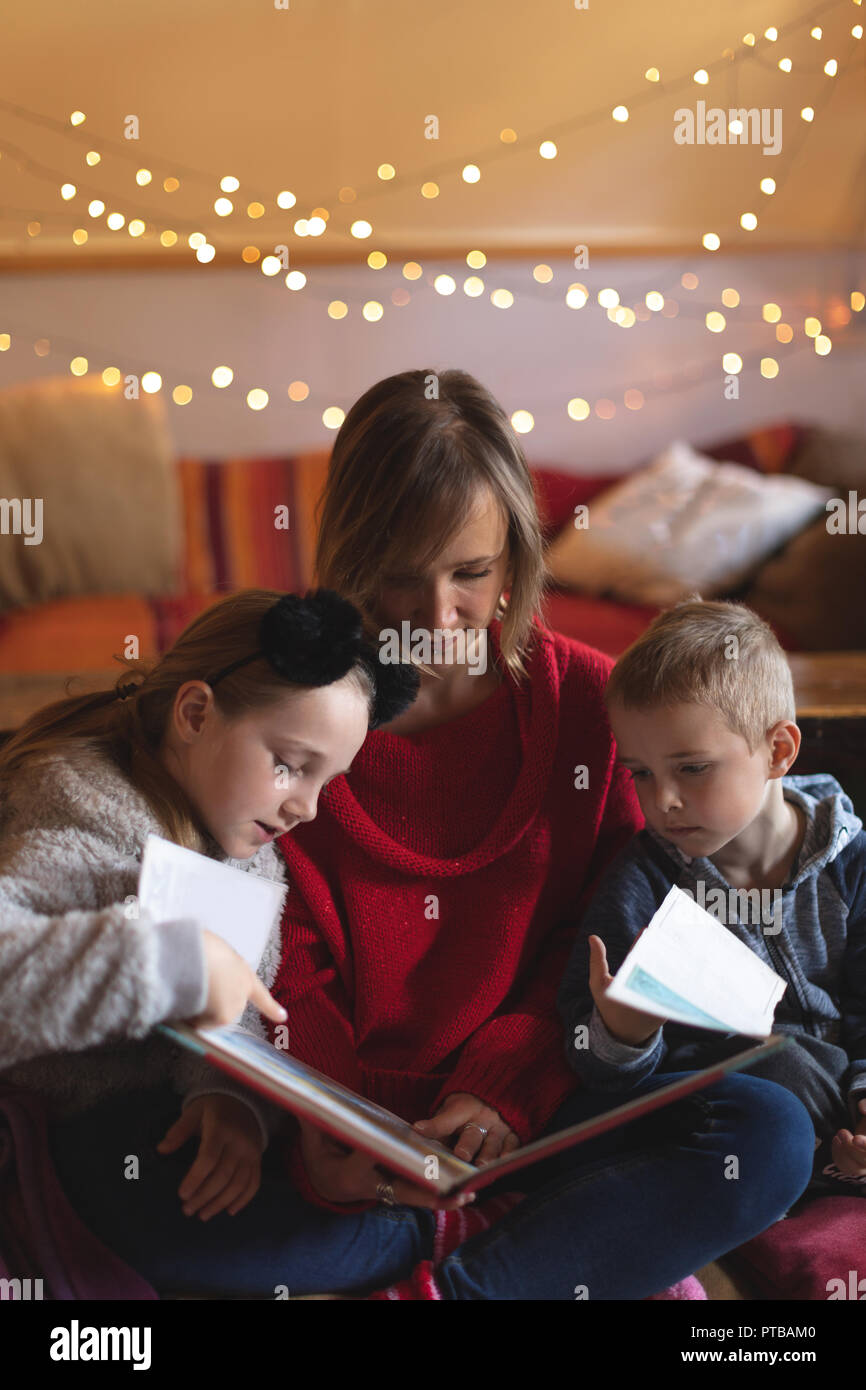 Mother and kids looking at a photo album at home Stock Photo