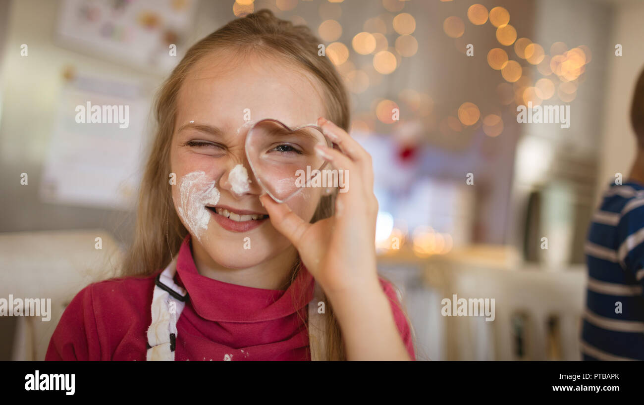 Girl showing a heart shaped cookie cutter Stock Photo