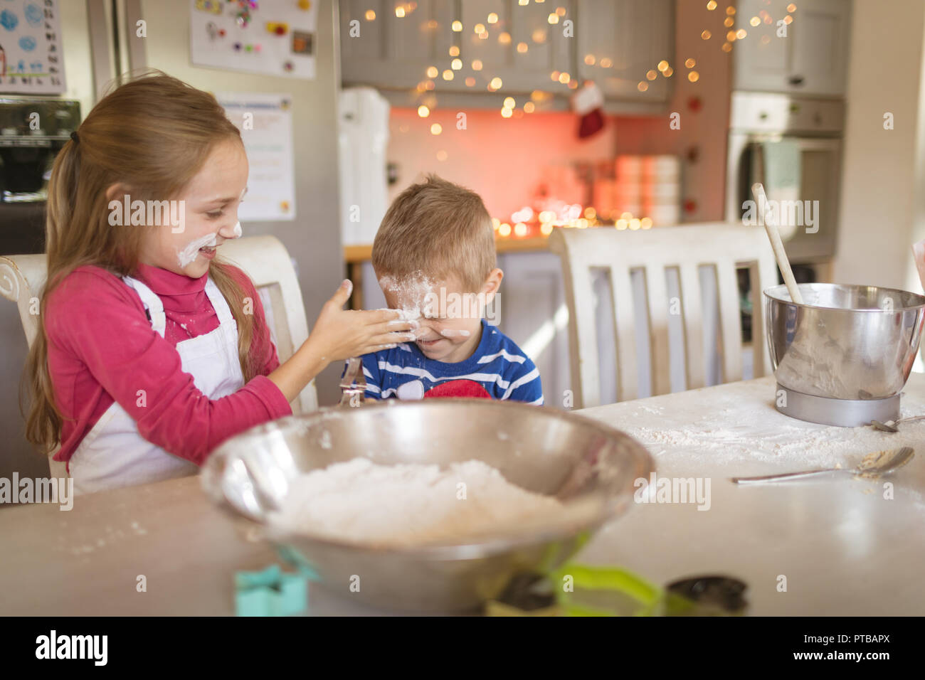 Siblings playing with flour in the kitchen Stock Photo