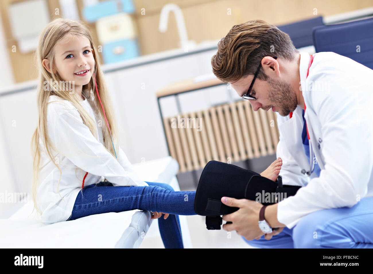 Picture showing little girl in clinic being examined by orthopaedist Stock Photo