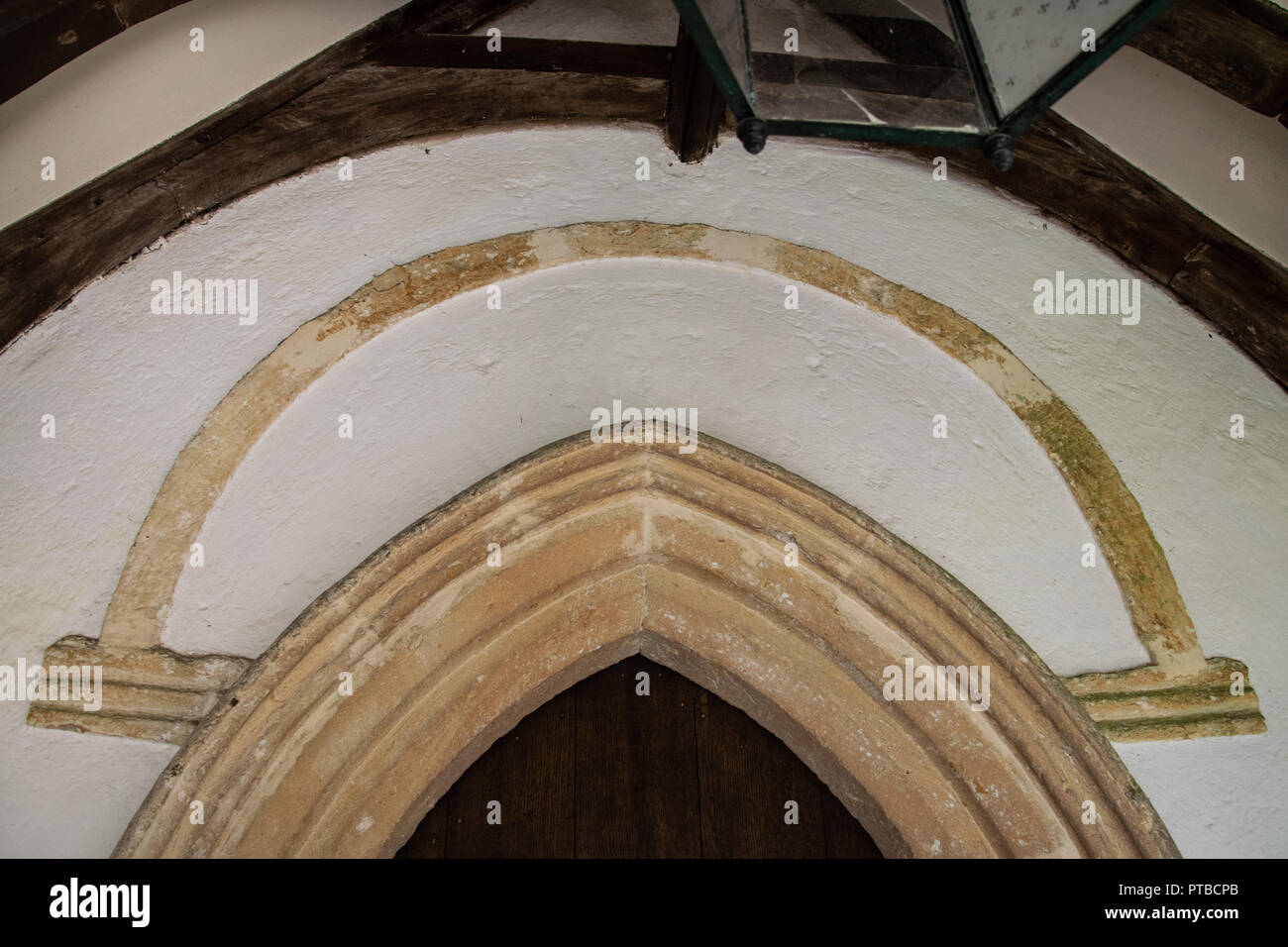 Saxon round arched nave doorway with hoodmould and moulded imposts, Church of St Andrew, Miserden Stock Photo