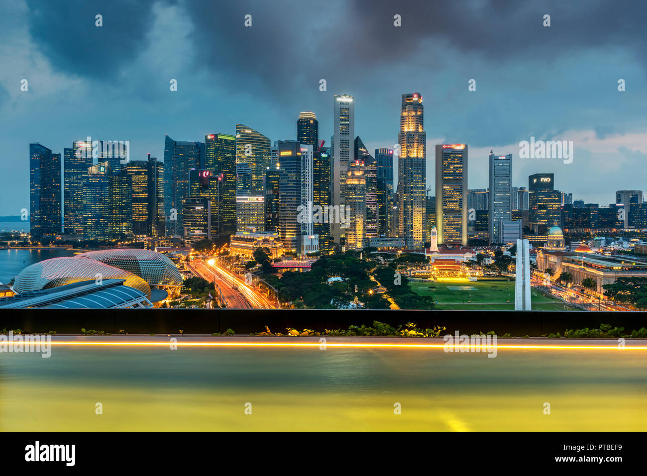 Infinity pool and financial district skyline at dusk, Singapore Stock Photo