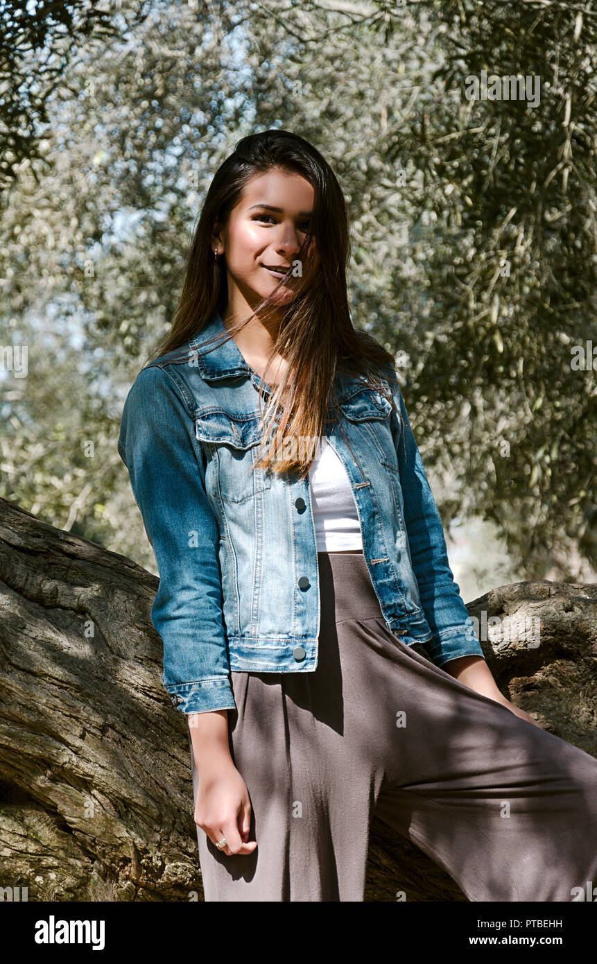 Beautiful Long Haired Teen Woman With Brown Hair Leaning On A Tree
