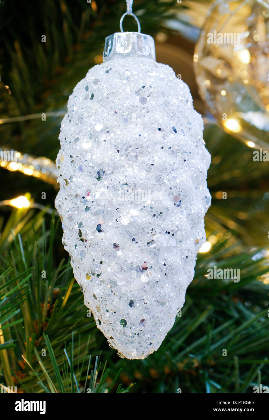 Close up of white Christmas decoration bauble hanging on tree Stock Photo