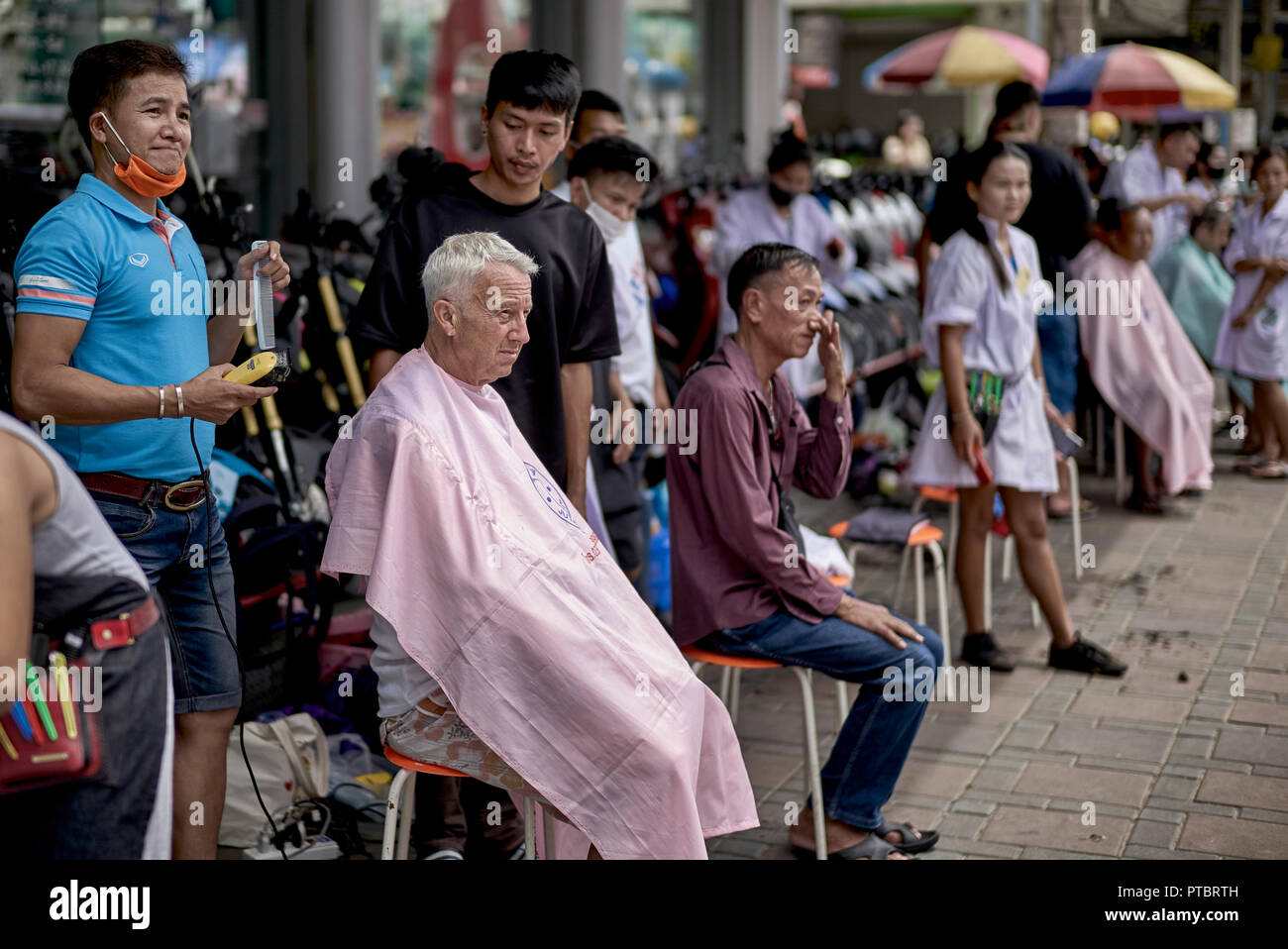 Street haircut. Business promotion of a local Thailand hair salon with  people getting a free haircut Stock Photo - Alamy