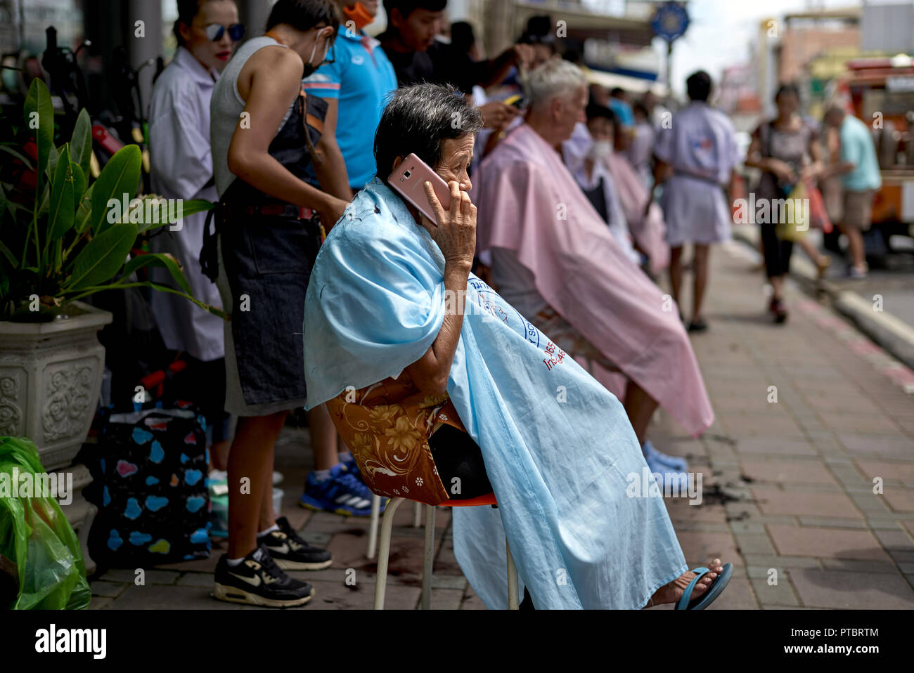 Street haircut. Business promotion of a local Thailand hair salon with people getting a free haircut Stock Photo