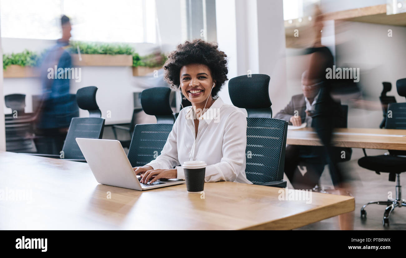 Portrait happy young businesswoman working in office. African woman ...