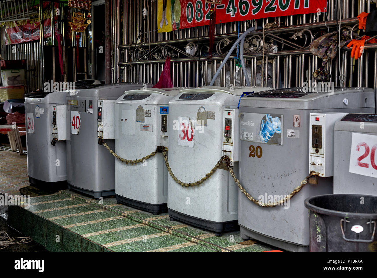 Washing machines. Coin operated self service street launderette . Thailand Southeast Asia Stock Photo