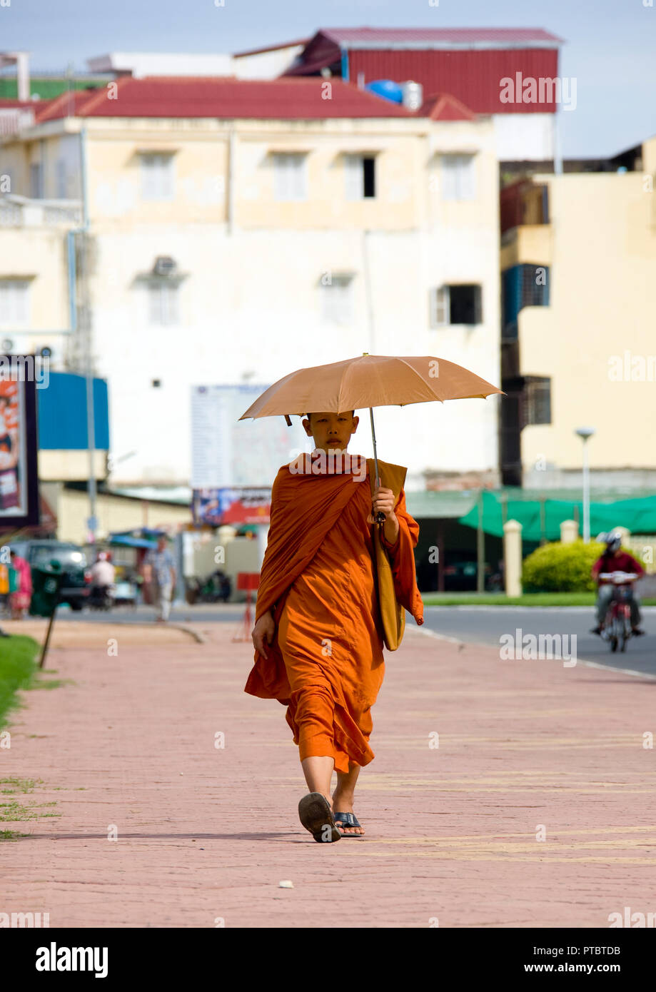 Cambodian monk walking in the street with umbrella, Phnom Penh province, Phnom Penh, Cambodia Stock Photo