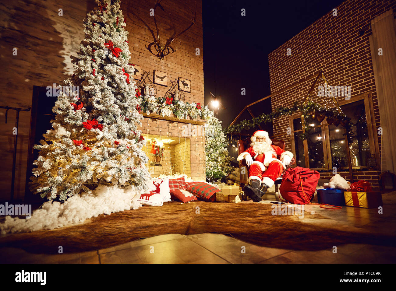 Santa Claus in a room with a fireplace in Christmas Stock Photo