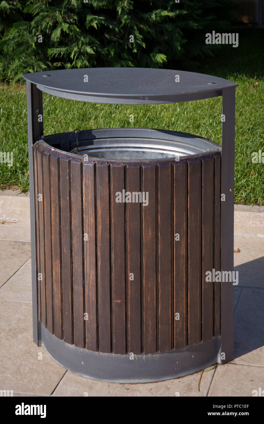 black garbage bin inside a wooden enclosure at a park. copy space on