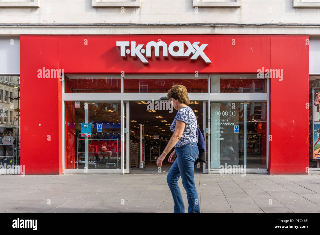 A woman walking past a TK MAXX store front in Southern England, UK, Europe Stock Photo