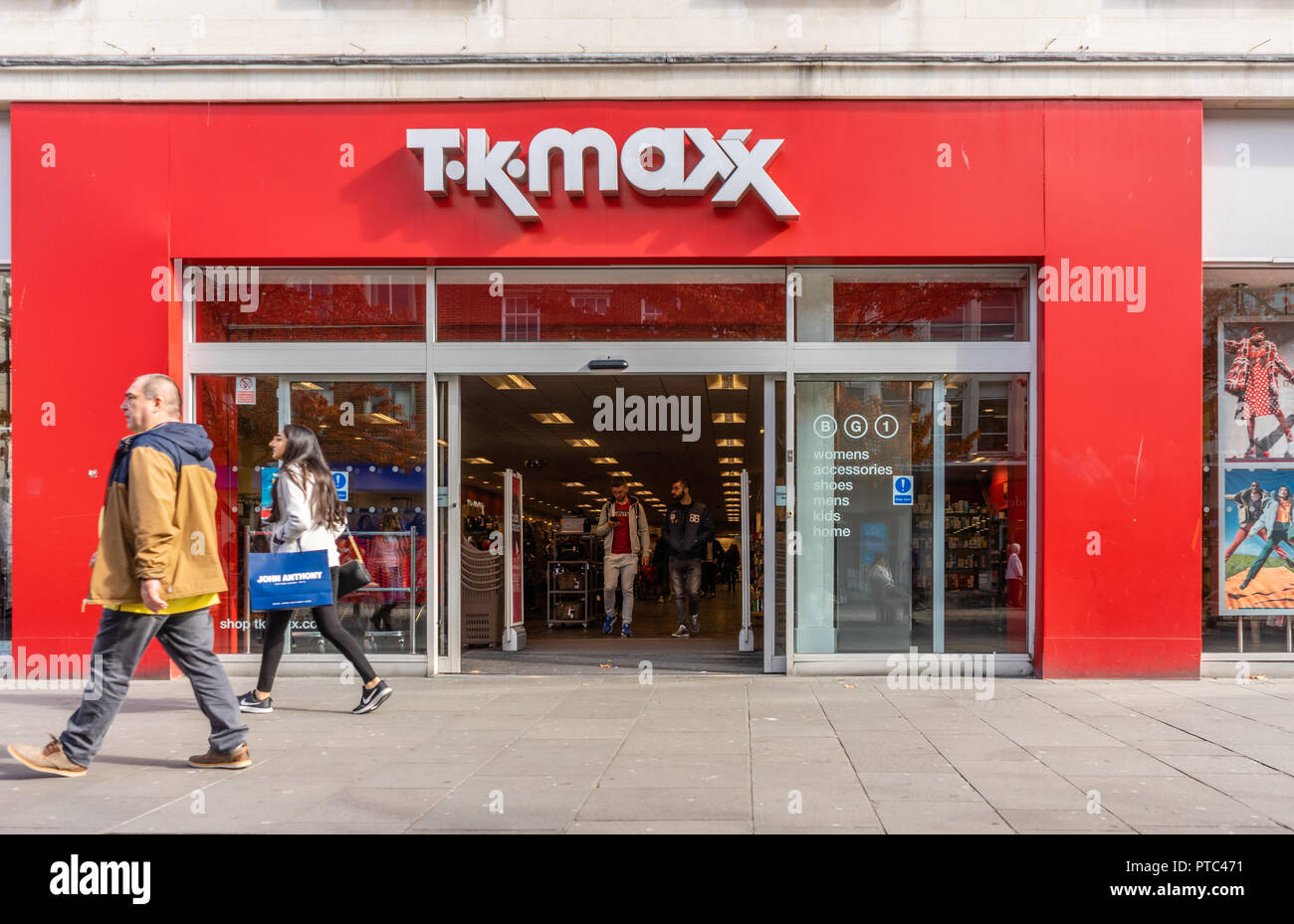 A woman walking past a TK MAXX store front in Southern England, UK, Europe Stock Photo