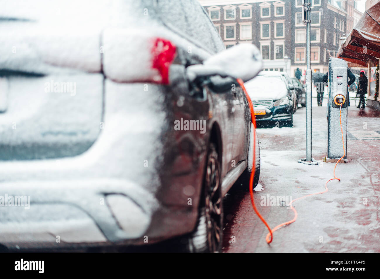 Electric car plug charging in the winter Stock Photo Alamy