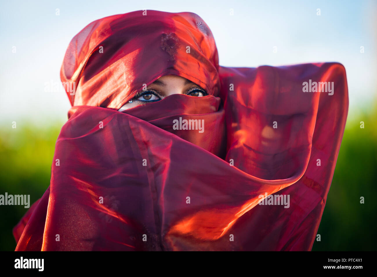 Close up view of brown woman eyes looking at camera, framed by headscarf Stock Photo