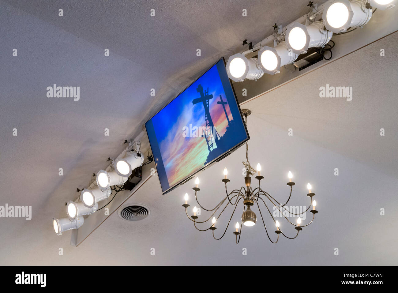 TV Monitor with Cross Image hangs from the ceiling of a Baptist Church in Florida. Stock Photo