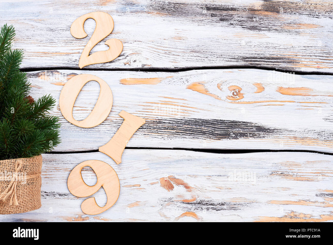 Christmas tree, number 2019, copy space. Little green Christmas tree and wooden numbers forming number 20189 on vintage wooden background, symbol of N Stock Photo