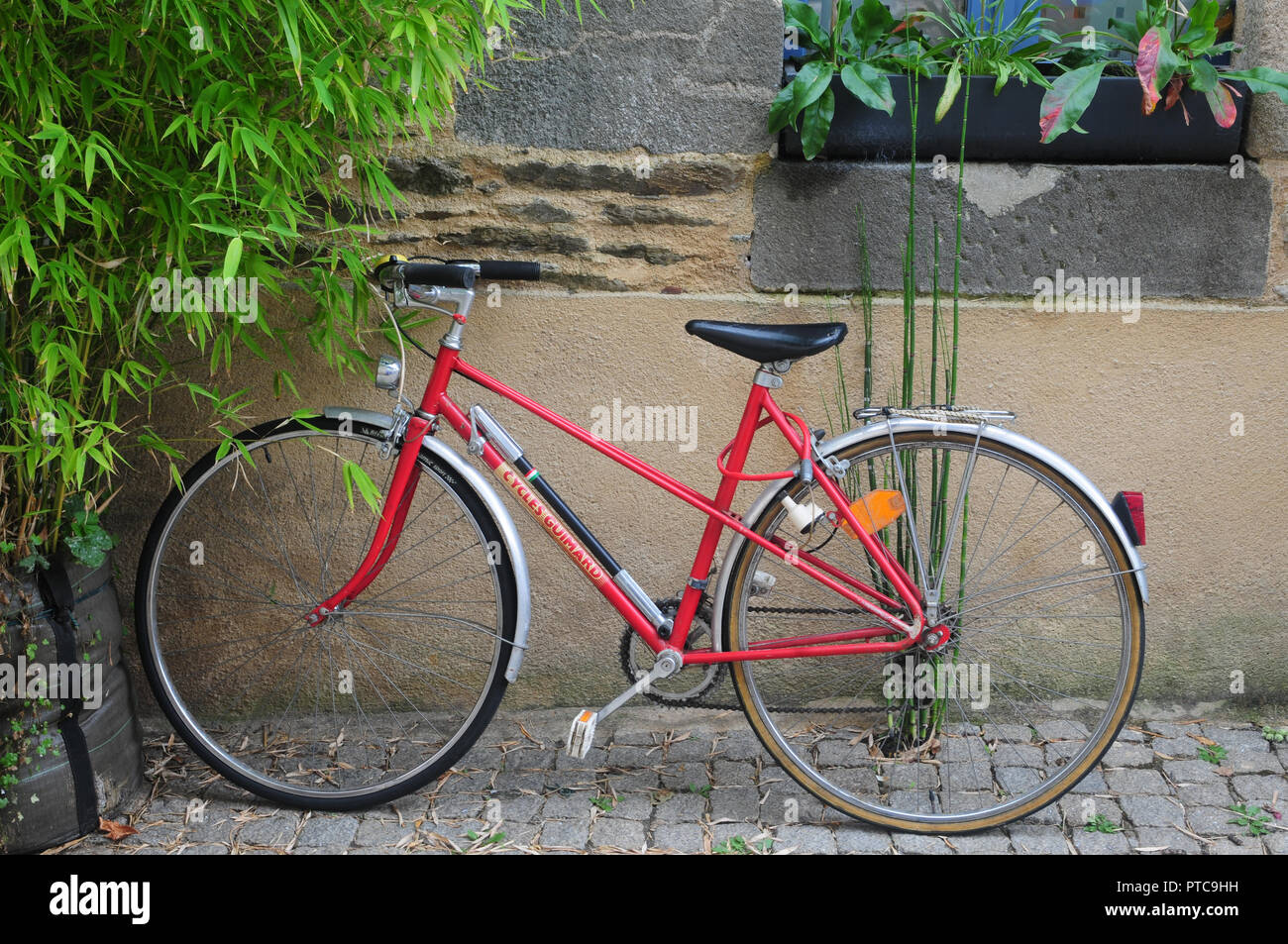 Stylish red bicycle parked in a French street Stock Photo