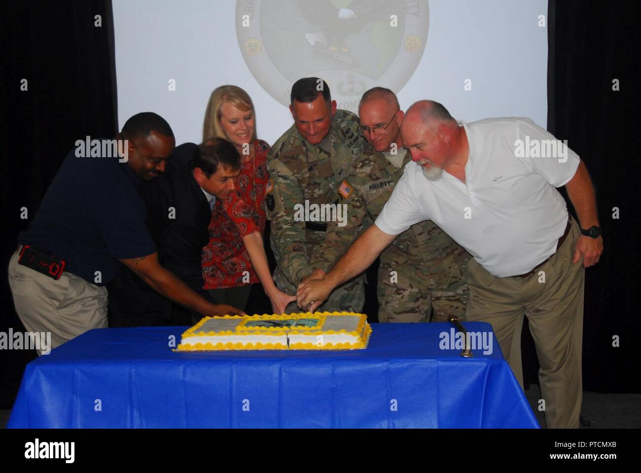 Brig. Gen. William E. King IV (center), commanding general of the 20th CBRNE Command from Aberdeen Proving Ground, Maryland, and Col. Thomas Holliday, Redstone Arsenal garrison commander, join special guests on July 10 to cut the cake that signifies the mission-ready status for the CARA-West team. This 37-member, highly specialized team completed a move this spring from Pinebluff Arsenal, Arkansas, to Redstone Arsenal next to Huntsville, Alabama. (20th CBRNE Command Stock Photo