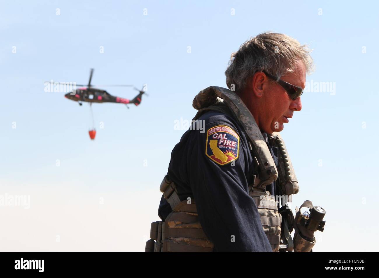 Capt. Bob Imnes, military helicopter manager of the California Department of Forestry and Fire Protection (CAL FIRE), preps his flight suit as a CalGuard UH-60 Black Hawk returns from battling the Garza Fire July 13 at the Coalinga Municipal Airport, Fresno County, California. Imnes and his CalGuard crew ran two missions, each about two hours, dropping water on the Kings County blaze. Stock Photo