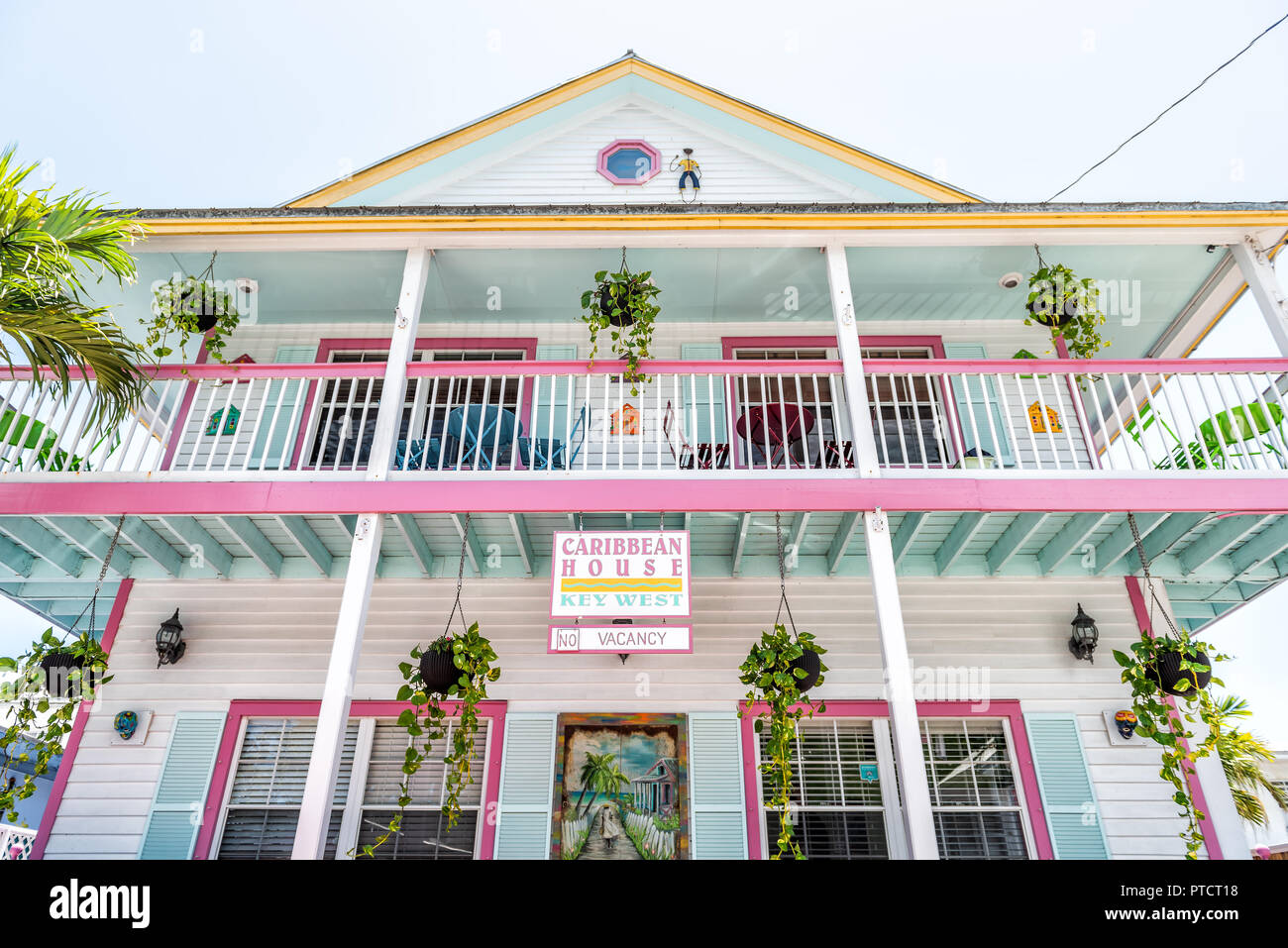 Key West, USA - May 1, 2018: Color pink and yellow architecture of hotel in famous city in Florida island on travel, sunny day, sign for Caribbean hou Stock Photo