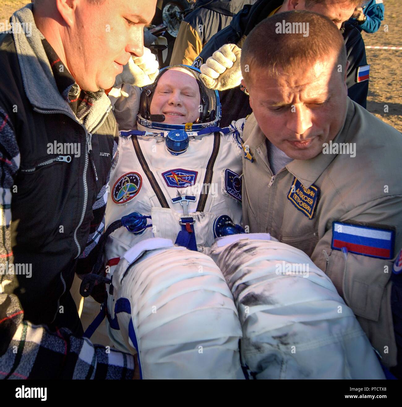 International Space Station Expedition 56 Soyuz Commander Oleg Artemyev is helped out from the Russian Soyuz MS-08 spacecraft shortly after landing October 4, 2018 near Zhezkazgan, Kazakhstan. Oleg Artemyev along with astronauts Drew Feustel and Ricky Arnold of NASA,are returning after 197 days in space. Stock Photo
