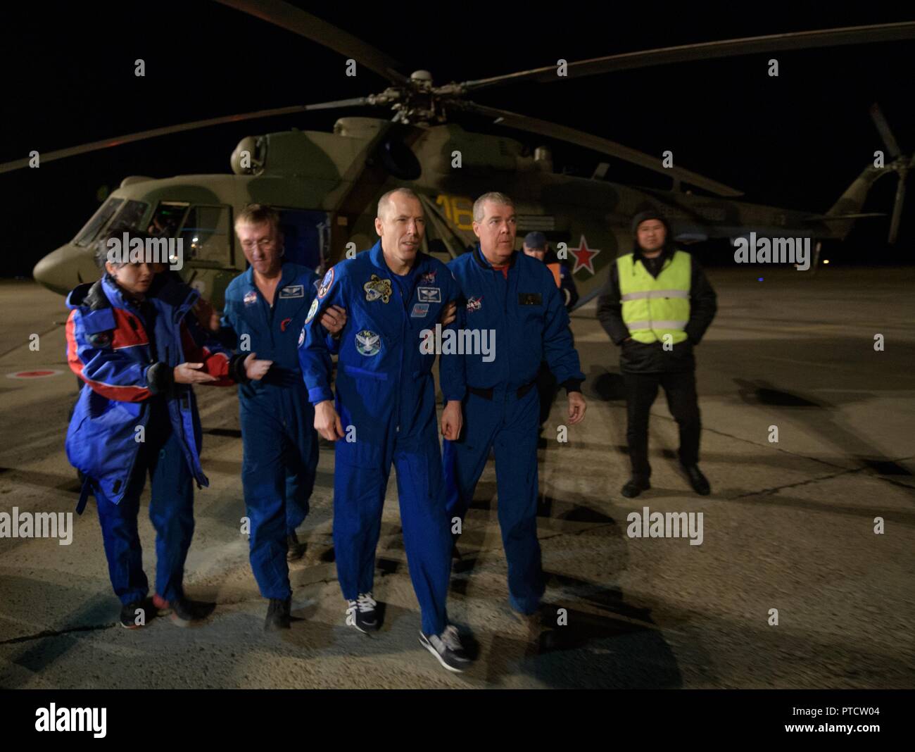 International Space Station Expedition 56 astronaut Drew Feustel is assisted as he arrives by helicopter to Karaganda Airport shortly after landing in the Russian Soyuz MS-08 spacecraft October 4, 2018 in Zhezkazgan, Kazakhstan. Stock Photo