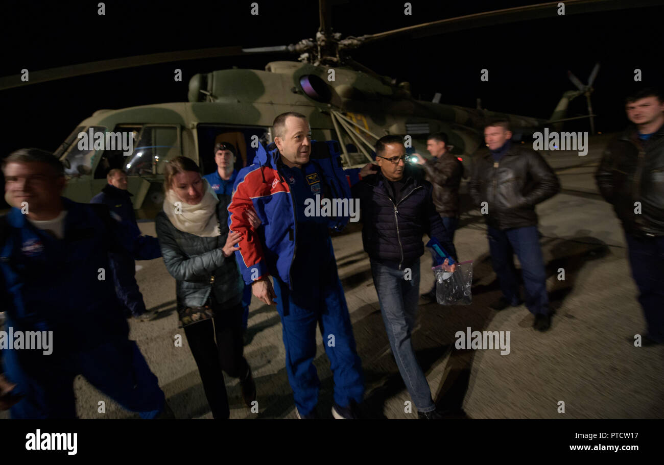 International Space Station Expedition 56 astronaut Ricky Arnold is assisted as he arrives by helicopter to Karaganda Airport shortly after landing in the Russian Soyuz MS-08 spacecraft October 4, 2018 in Zhezkazgan, Kazakhstan. Stock Photo