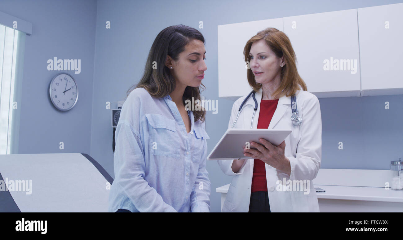 Closeup of doctor using high tech tablet to review health history with patient Stock Photo