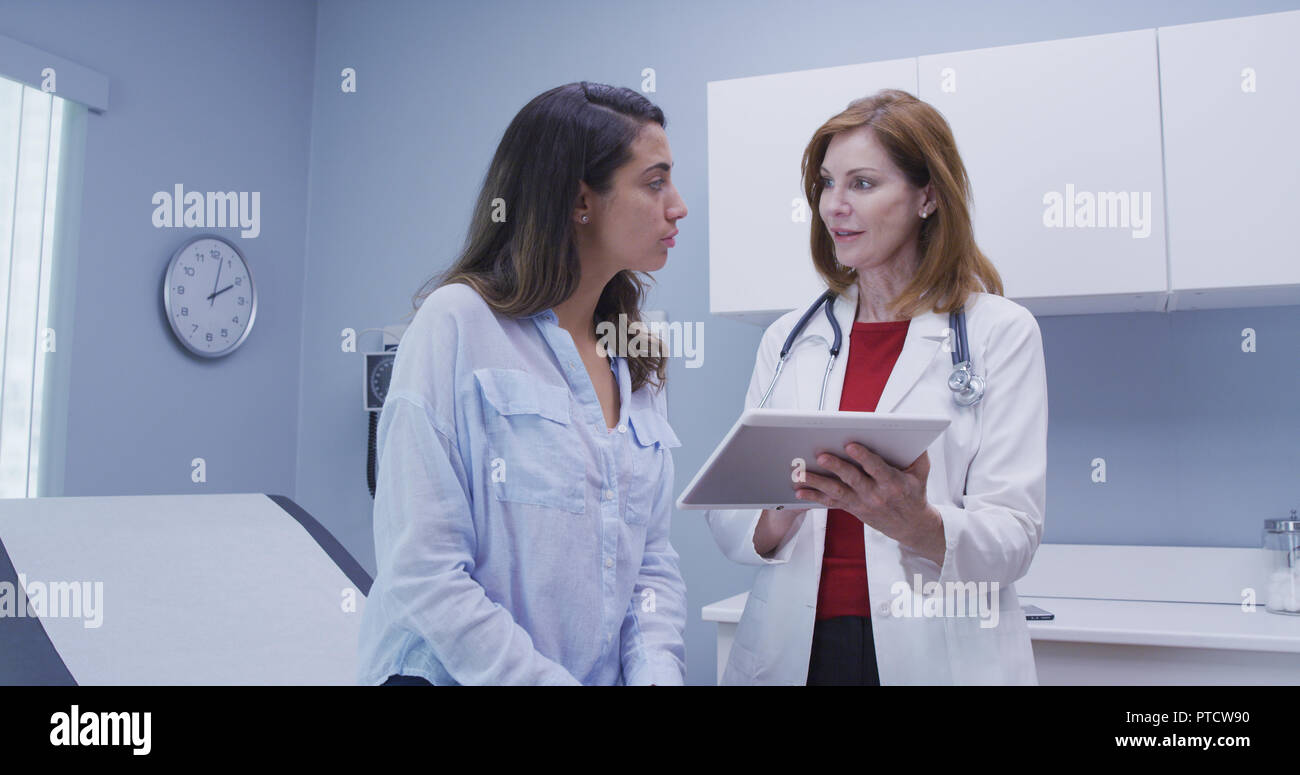 Closeup of doctor using high tech tablet to review health history with patient Stock Photo